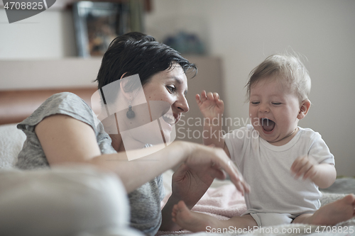 Image of mother is playing with baby at home