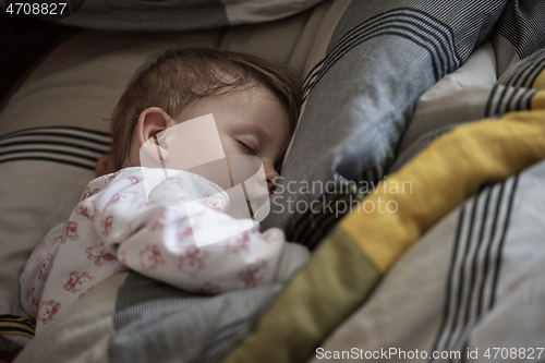 Image of newborn baby sleeping at home in bed