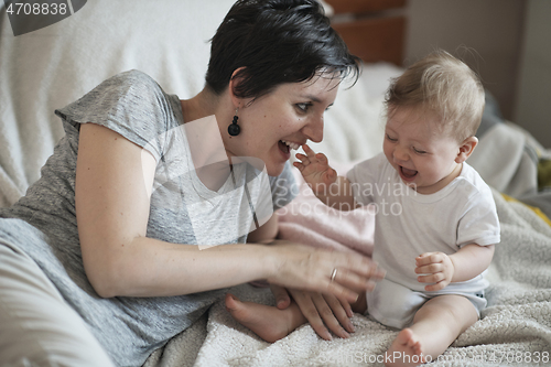 Image of mother is playing with baby at home