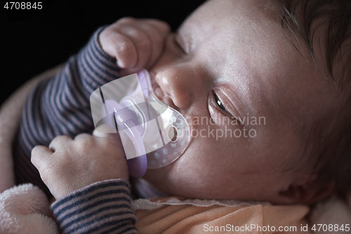 Image of One month newborn baby sleeping in bed