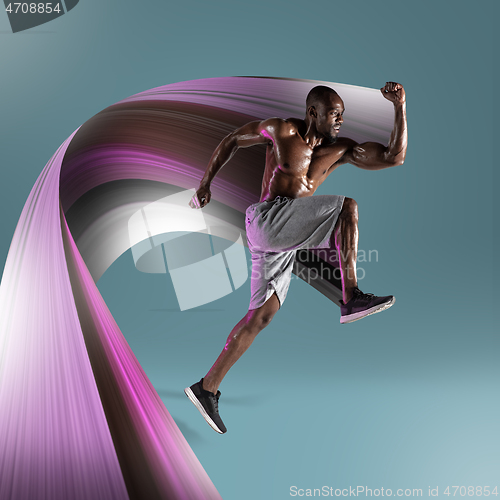 Image of Young african-american athlete training over blue background