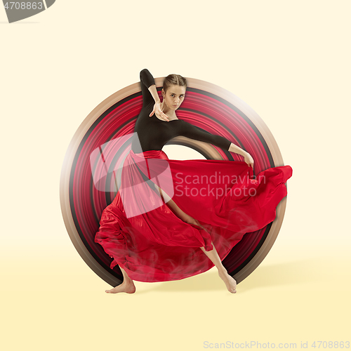 Image of Young graceful female dancer dancing over yellow studio