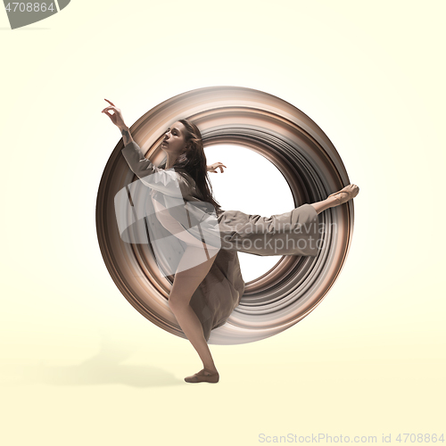 Image of Ballerina. Young graceful female ballet dancer dancing over yellow studio. Beauty of classic ballet.