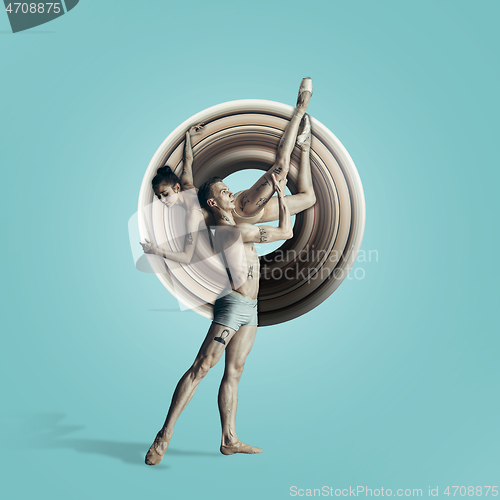 Image of Young graceful couple of ballet dancers dancing over blue studio. Beauty of classic ballet.
