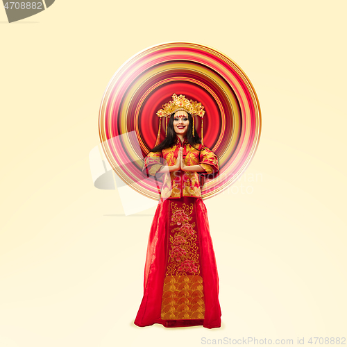 Image of Woman standing in red traditional costume