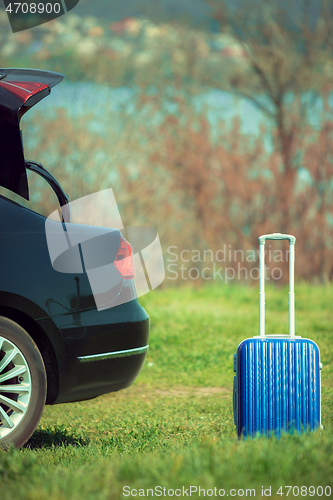 Image of View of modern black car and suitcase on the river\'s side