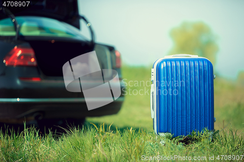 Image of View of modern black car and suitcase on the river\'s side