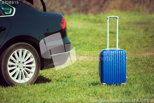 Image of View of modern black car and suitcase on the river\'s side