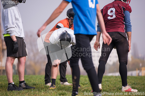 Image of american football players stretching and warming up