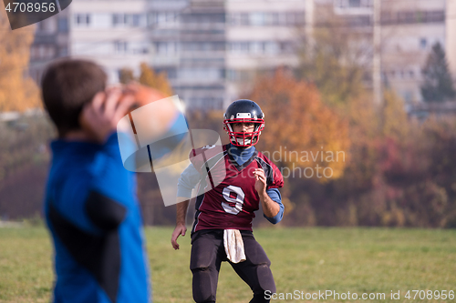 Image of american football team with coach in action