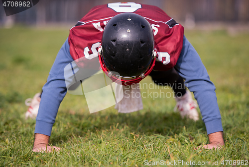 Image of american football player doing push ups