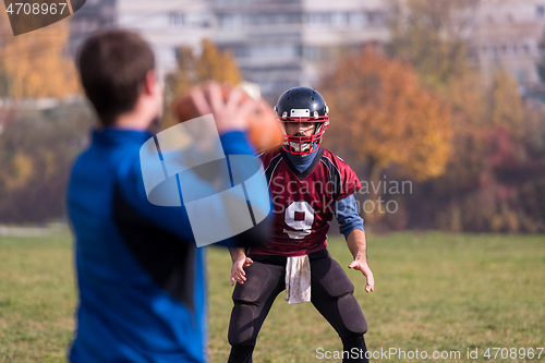 Image of american football team with coach in action