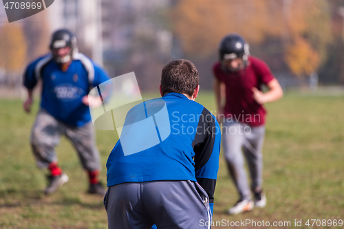 Image of american football team with coach in action