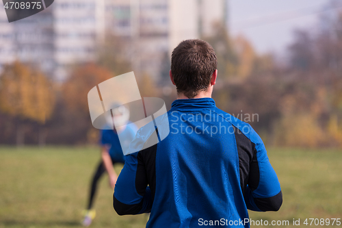 Image of american football team with coach in action