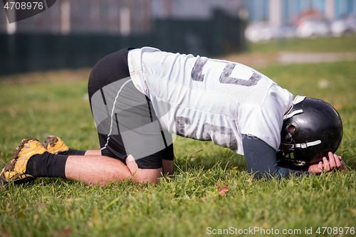 Image of american football player resting after hard training