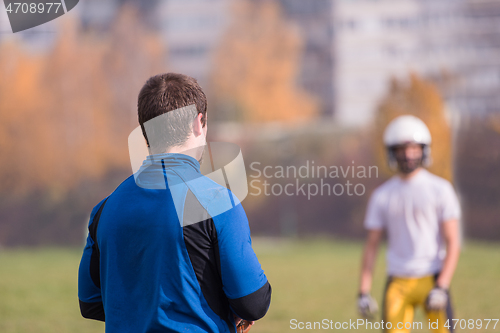 Image of american football team with coach in action