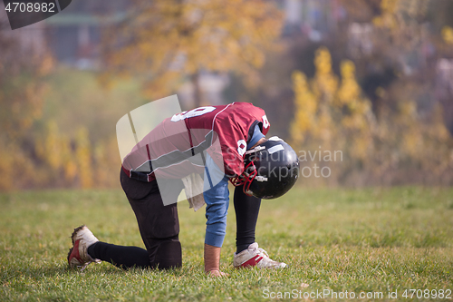 Image of american football player resting after hard training