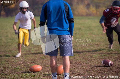 Image of american football team with coach in action