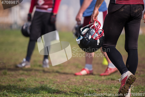 Image of American football player holding helmet