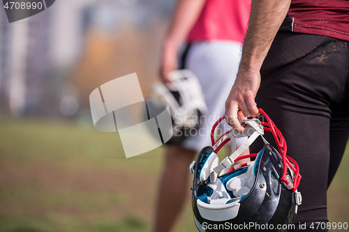 Image of American football player holding helmet