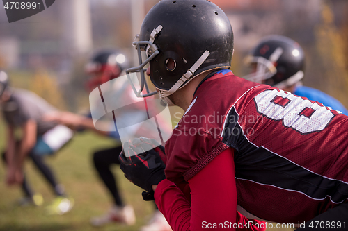 Image of american football players stretching and warming up