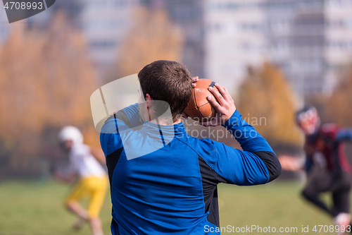 Image of american football team with coach in action