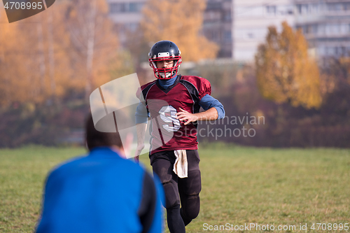 Image of american football team with coach in action