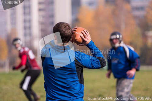 Image of american football team with coach in action