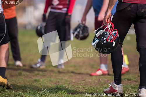 Image of American football player holding helmet