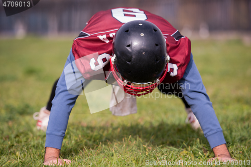 Image of american football player doing push ups