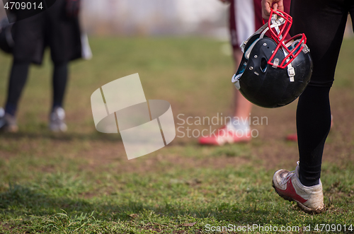 Image of American football player holding helmet