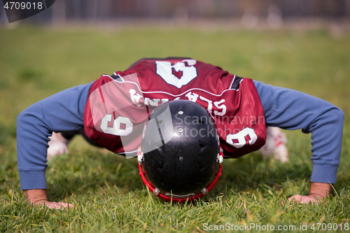 Image of american football player doing push ups