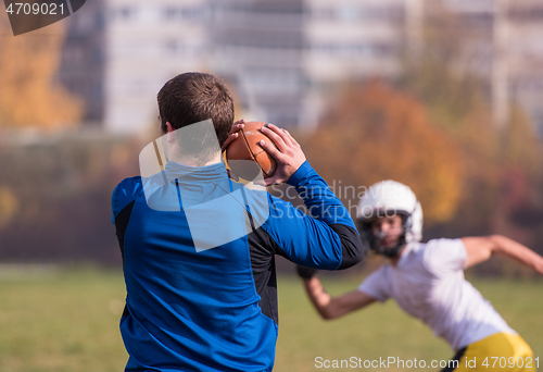 Image of american football team with coach in action