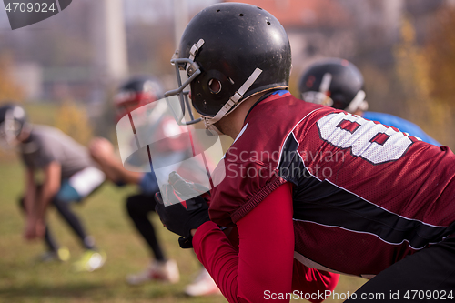 Image of american football players stretching and warming up