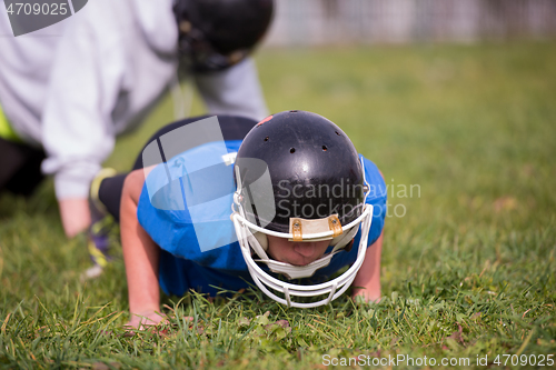 Image of american football player doing push ups
