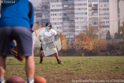 Image of american football team with coach in action