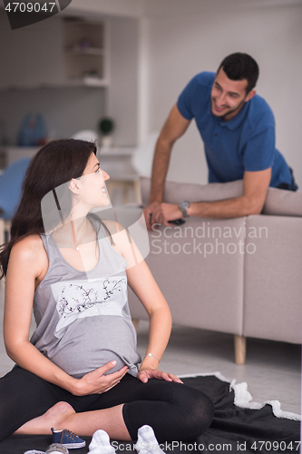 Image of pregnant couple checking a list of things for their unborn baby