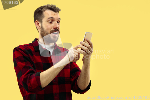 Image of Half-length close up portrait of young man on yellow background.