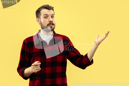 Image of Half-length close up portrait of young man on yellow background.