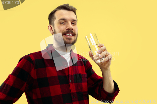 Image of Half-length close up portrait of young man on yellow background.