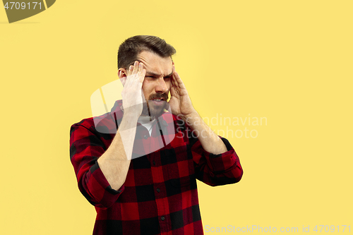 Image of Half-length close up portrait of young man on yellow background.