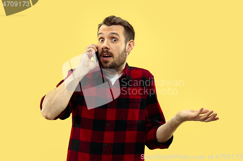 Image of Half-length close up portrait of young man on yellow background.