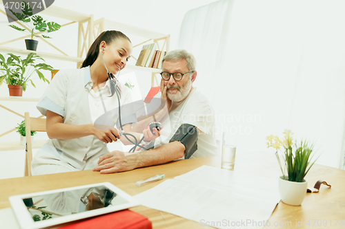 Image of The visiting nurse taking care of senior man