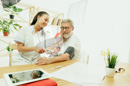 Image of The visiting nurse taking care of senior man