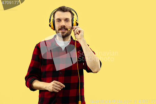 Image of Half-length close up portrait of young man on yellow background.