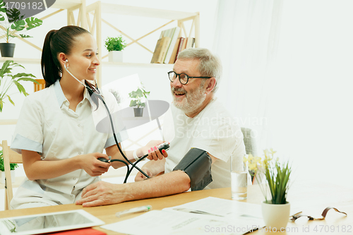 Image of The visiting nurse taking care of senior man