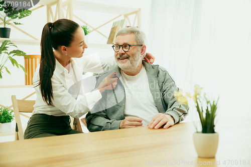 Image of A daughter or granddaughter spends time with the grandfather