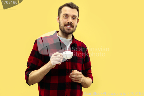 Image of Half-length close up portrait of young man on yellow background.