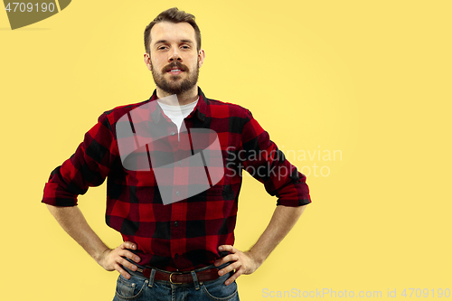 Image of Half-length close up portrait of young man on yellow background.