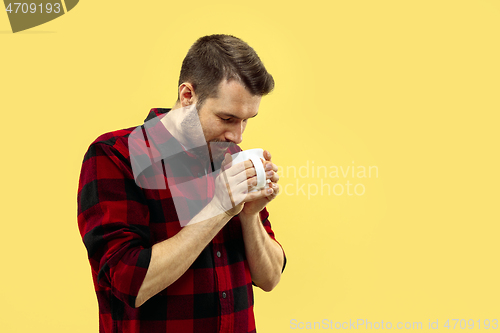 Image of Half-length close up portrait of young man on yellow background.